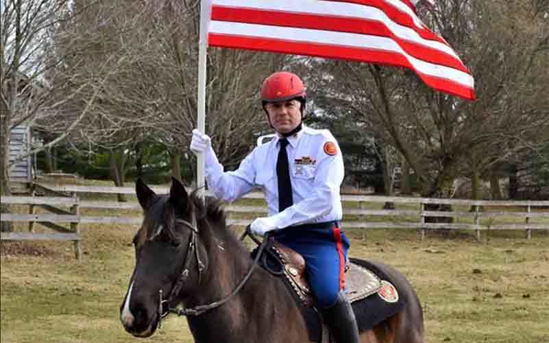 Riders of the mounted color guard on horseback carrying flags